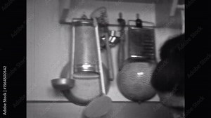 Vintage film, Woman in kitchen cooking food, black white archival. Mother preparing meat meal for family at home. Kitchen utensils. Classic housewife in retro 1960s archive. Homemaker in archives