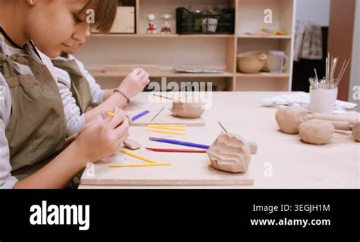 Craft activity. Art studio. Two creative kids shaping ceramic molding handmade raw using color tool in professional pottery workspace Stock Video Footage - Alamy