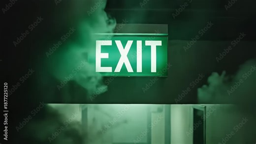 Exit Sign in Smoke Filled Hallway - A glowing green "EXIT" sign hangs above a doorway in a smoke-filled hallway. The smoke obscures part of the sign and doorway creating a sense of emergency.