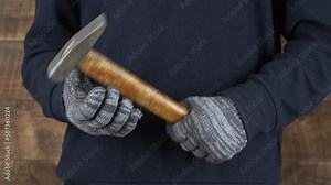 Man worker hand holding a old hammer and beating hand with it, close up, concept for repair work