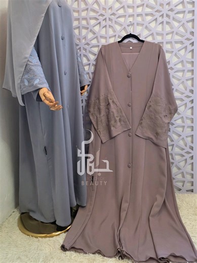 New button-down abaya featuring a contemporary V-neckline and a structured fit, elevated by tonal floral embroidery on the sleeves. Crafted in premium nida fabric. Available in size 52 to 58 #modestfashion #ramadancollection2026