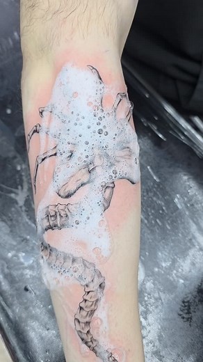 Just finished this awesome face hunter tattoo, totally inspired by my alien series! It's been a blast bringing these cosmic characters to life on skin. This one's got so much personality, I'm really digging it. Can't wait to see how it heals up and becomes part of someone's collection. Thinking about doing a whole lineup of these guys! What do you think? #FaceHunter #AlienTattoo #TattooArt #CosmicVibes | Juan Guillermo Manco