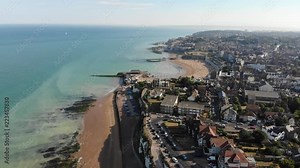 Fly over Eastern Promenade, Broadstairs, Kent, at sunset. Broadstairs Harbour Car Park, Viking Bay, sandy beach, Victoria Gardens and the man-made paddling pool at low tide.