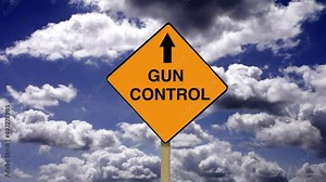 Gun control on an orange diamond road sign. Firearm control regulations, laws and restrictions. Politics and legislation intended to restrict the use, access and possession of guns and firearms.