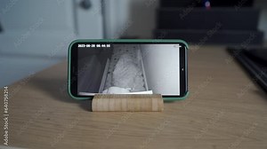 using ip wireless security camera as baby video monitor on mobile phone, watching sleeping toddler child in real-time.