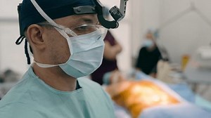 Close up guy man doctor medic physician neurosurgeon anesthetist surgeon in uniform prepare patient for surgical operation in operating room covid-19 health medicine in hospital clinic medical surgery