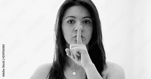 Black and white clip of Young woman saying to keep quiet with finger - shh sign in B&W