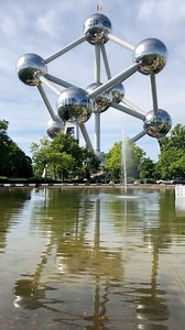 The Atomium, located in Brussels, Belgium, is a striking architectural marvel representing a unit cell of an iron crystal magnified 165 billion times. Designed by engineer André Waterkeyn and architects André and Jean Polak, it consists of nine 18-meter-diameter stainless steel spheres connected by tubes to form the shape of a body-centered cubic crystal. This geometric structure reflects a blend of science and art, capturing the optimism of the atomic age through its futuristic design and symme