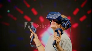 The beautiful woman wearing VR headset dancing in virtual reality. The woman moves activity in modern virtual reality dance game.Led screen with blur background.Concept high technology digital device
