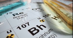 Test tubes with blue and yellow liquid on the periodic table in a chemical laboratory