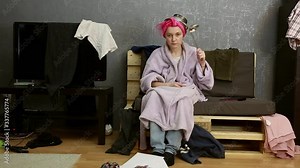 Tired woman. The house is a mess. Things scattered around the room. A woman goes crazy with homework. Humor.