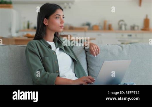 Pensive Indian woman using laptop computer thinking typing freelancer at home student Arabian female ethnic girl businesswoman browsing online shopping booking food delivery order internet app indoors Stock Video Footage - Alamy