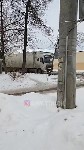 White Semi-Truck Navigating Snowy Urban Roads