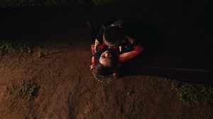 a couple of lovers hugging each other and making out on the ground staring at each other