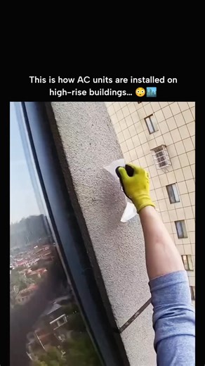 GLOBAL EXPLAINED on Instagram: "Installing an AC unit in high-rise buildings is a highly skilled and dangerous task. Workers must brave dizzying heights as they climb outside windows, exemplifying their courage and expertise. To ensure their safety, they meticulously drill holes in the building’s exterior walls to secure heavy-duty safety harnesses. This step is critical to prevent any accidents during the installation process. Once secured, the AC fan is carefully maneuvered through the window 