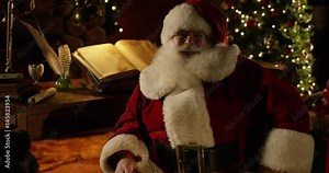 Santa Claus lets out a jolly laugh and gestures with both hands