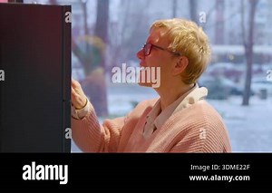 Senior Caucasian lady with short blonde hair, wearing glasses and formal business clothes, having business conversation on smartphone in office