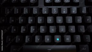 The word phone is typed on a luminous computer keyboard. Black backlit keyboard with letters. The keyboard itself prints the word using the backlight.