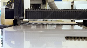 Video from automated production. CNC plasma cutter working on metal with sparkling hot gas. A robotic automotive arm with electronic laser cutting