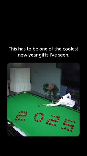 The Vexia on Instagram: "An elaborate billiards trick shot where numerous red balls are meticulously arranged on a pool table to form the word “LOVE,” with a white cue ball positioned for the break. As the player strikes the cue ball with precise force and angle—accompanied by a French voice exclaiming “C’est parti!”—the balls scatter in a controlled chaos, seamlessly rearranging into the digits “2025” to symbolize a New Year’s transition into 2026. This impressive display of artistic pool relie