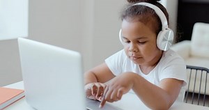 Afro american kid girl school pupil wearing headphones studying online from home watching web class lesson or listening tutor by video call elearning on pandemic isolation. Children remote education.