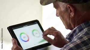 Senior analyzing interactive tablet dashboard with dynamic charts and graphs