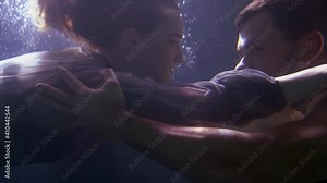 romantic loving couple underwater, young man and woman are floating in depth of sea, ocean or river