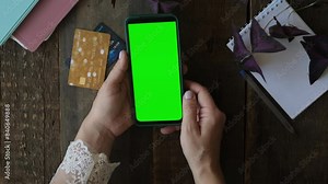 Online payments, mobile app mockup. Hands scrolling green screen on smartphone.