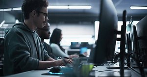 Young Passionate Specialist Working on Computer, Programming a Software for an Innovative Technological Internet Product Launch. Diverse Multicultural Team Working in a Startup Agency
