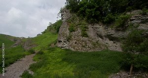 view of the limestone outcrop with path left a frame at cave Dale, Castleton