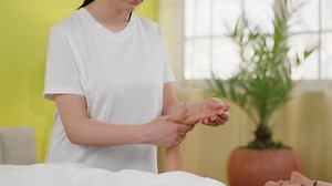 At private massage room woman have a full body relaxation massage the masseur woman take the hand of the client and with some oil massage oil. 4k