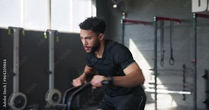 Man, workout and exercise bike in gym for fitness, training and health with cardiovascular benefits. Athlete, cycling and elliptical machine for weight loss, muscle growth or endurance with intensity