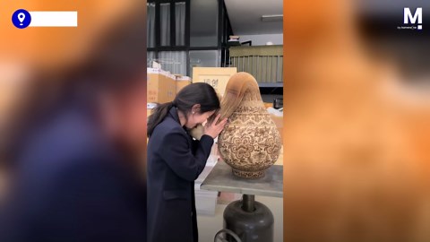 Museum visitor amazed by realistic-looking vase made entirely of paper