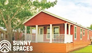 The massive living room is the perfect place to gather for a meal or enjoy a relaxing nap on the couch. Real wood cabinets are offset by sleek, modern, black kitchen appliances. These include a full electric range, refrigerator, microwave, and dishwasher. The kitchen is spacious with plenty of room for family members to stay comfortable while you’re trying to prepare a meal. Cruising down the hall, Brain shows us a bedroom that features a queen bed. Real wood doors unveil a large closet for thos