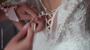 The bride wears a wedding dress, the girl helps to dress the bride's wedding dress.