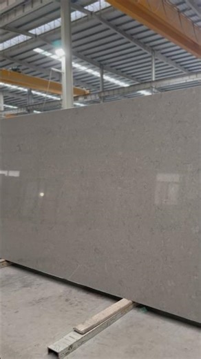 A concrete-look quartz slab featuring a soft grey tone with subtle mineral texture.