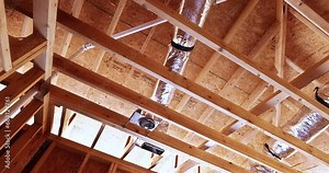 Worker installs hvac hood, electrical wires, ceiling light, insulation before installing plasterboard for new house