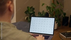 Man working with laptop at home, browsing internet or application with blank screen mockup for your design at home office with blurry background with free space for custom text about business