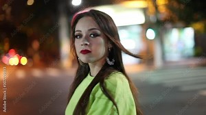 Woman walking at night in city street while smoking cigarette slow-motion