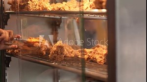 restocking in the food display case. restocking of fried chicken in the food display case