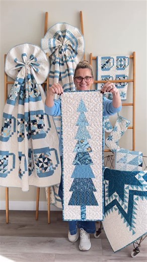 Edyta Sitar on Instagram: "✨ Holiday cozy is officially on: blue quilts, warm lights, and a little tree magic on the wall 💙🌲 #HolidayDecor #CozyHome #BlueQuilts #HandmadeHome #WallHanging #WinterVibes #FestiveSeason #QuiltLove #HomeStyling #HolidayInspiration"