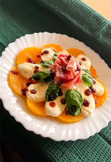 Persimmon appetizer This recipe is easy to make and super tasty. 🧀 What you’ll need: 1 persimmon Prosciutto 125g mozzarella Basil leaves Basil cream French herbs Direction: 1. Depending on, if you prefer your persimmon extra sweet or not that much, you can keep it in the kitchen for a few more days until it softens for extra sweetness. 2. Cut it in slices and arrange it on a plate. 3. Cut the mozzarella and add it on top. 4. Make a rose out of prosciutto slices and add it on top. 5. Add basil l