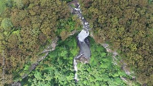Aerial top down view over Purling Brook falls, with a zoom out and pan up to reveal lower pool and surrounds. Springbrook National Park, Gold Coast hinterland