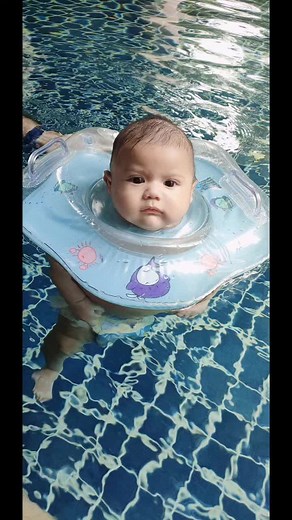 Baby Swimming with Floatation Device in Outdoor Pool