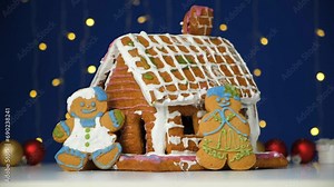 Christmas gingerbread in the shape of men is decorated with colorful sugar icing and a cookie house.