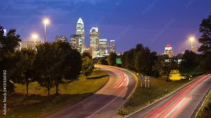 Awesome Charlotte NC City Skyline Timelapse with Fast Moving Traffic From Day to Night featuring Iconic Buildings with Vibrant Colors on a Summers Evening in North Carolina