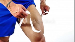 Muscular bodybuilder man measuring thigh with tape measure