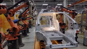 AI automation robotic automatic conveyor line with robotic arms that perform welding work in an electric vehicle factory.