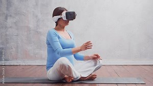 Young pregnant woman in VR helmet. She is preparing for the birth of a child on a virtual simulator. Augmented reality technology concept.