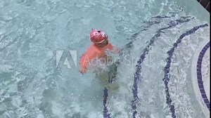 Little girl having fun swimming in outdoor pool